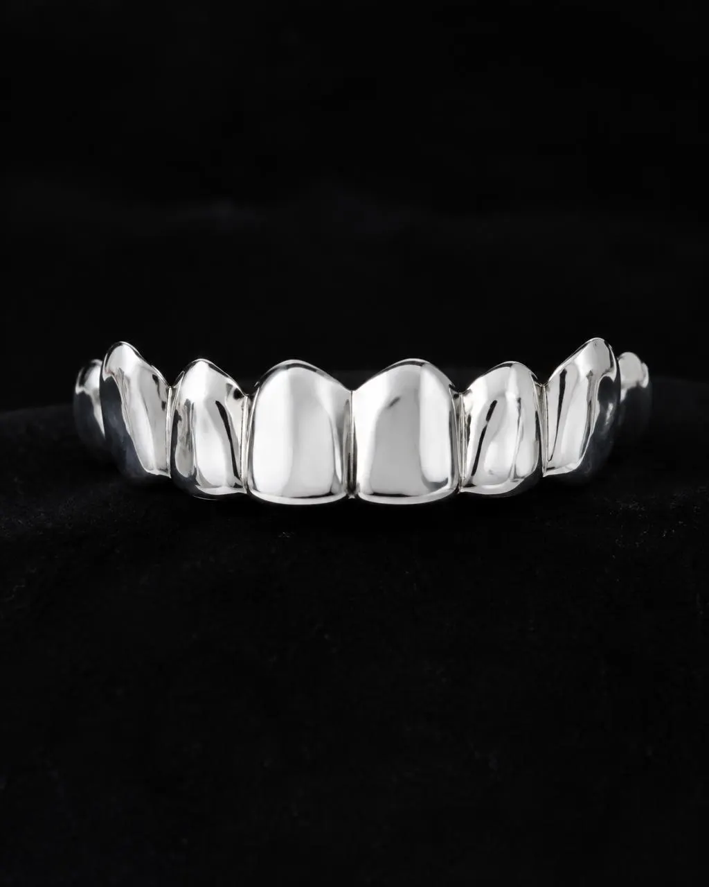 Top row of polished silver grillz