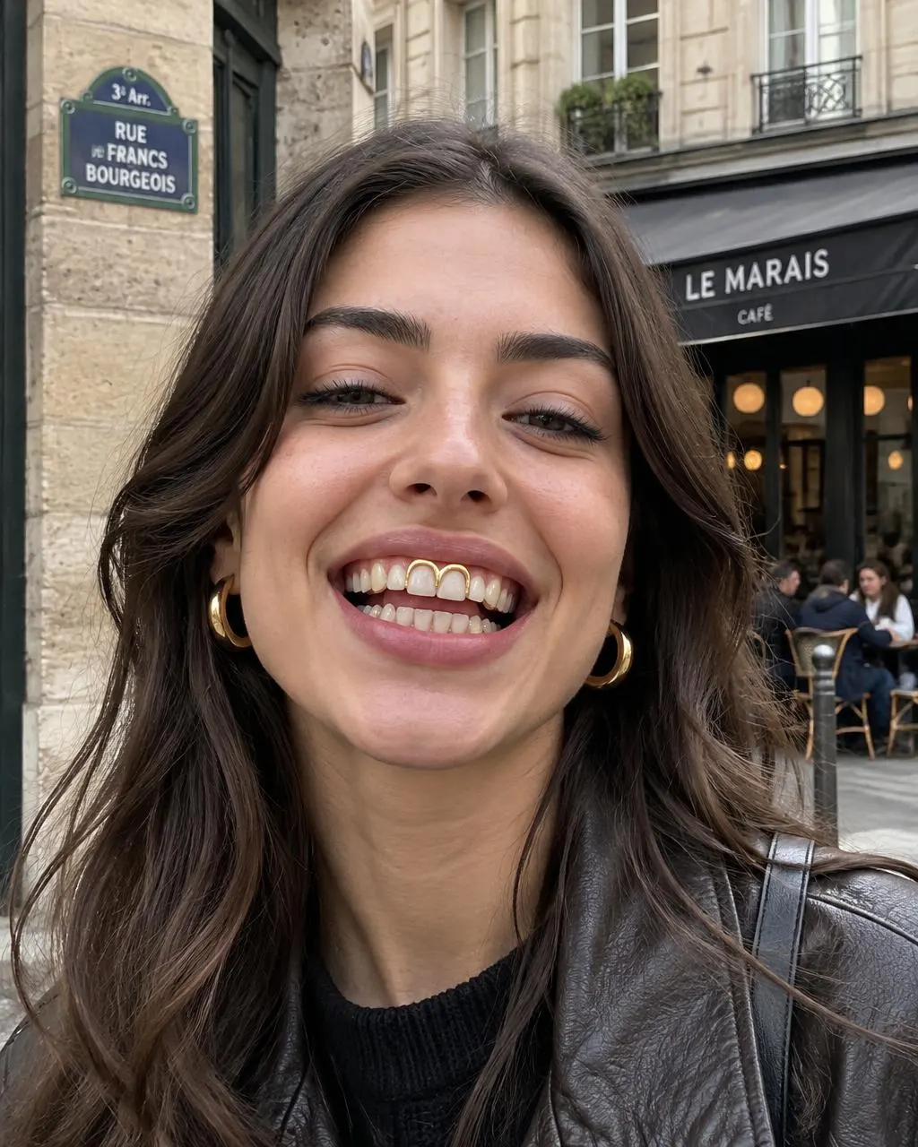Woman in Le Marais smiling with open-face 14K gold grillz outlining two front teeth